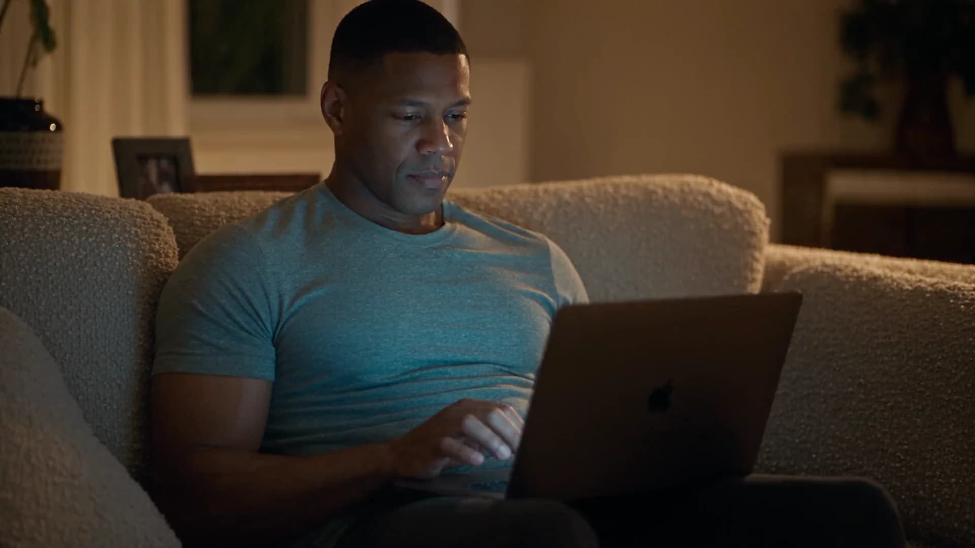 A man on a sofa, laptop open, reading his lab results in Omnis Body.